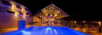 Área de restaurante y piscina iluminada en el lodge Sumaj Lagoon Blue – Laguna Azul